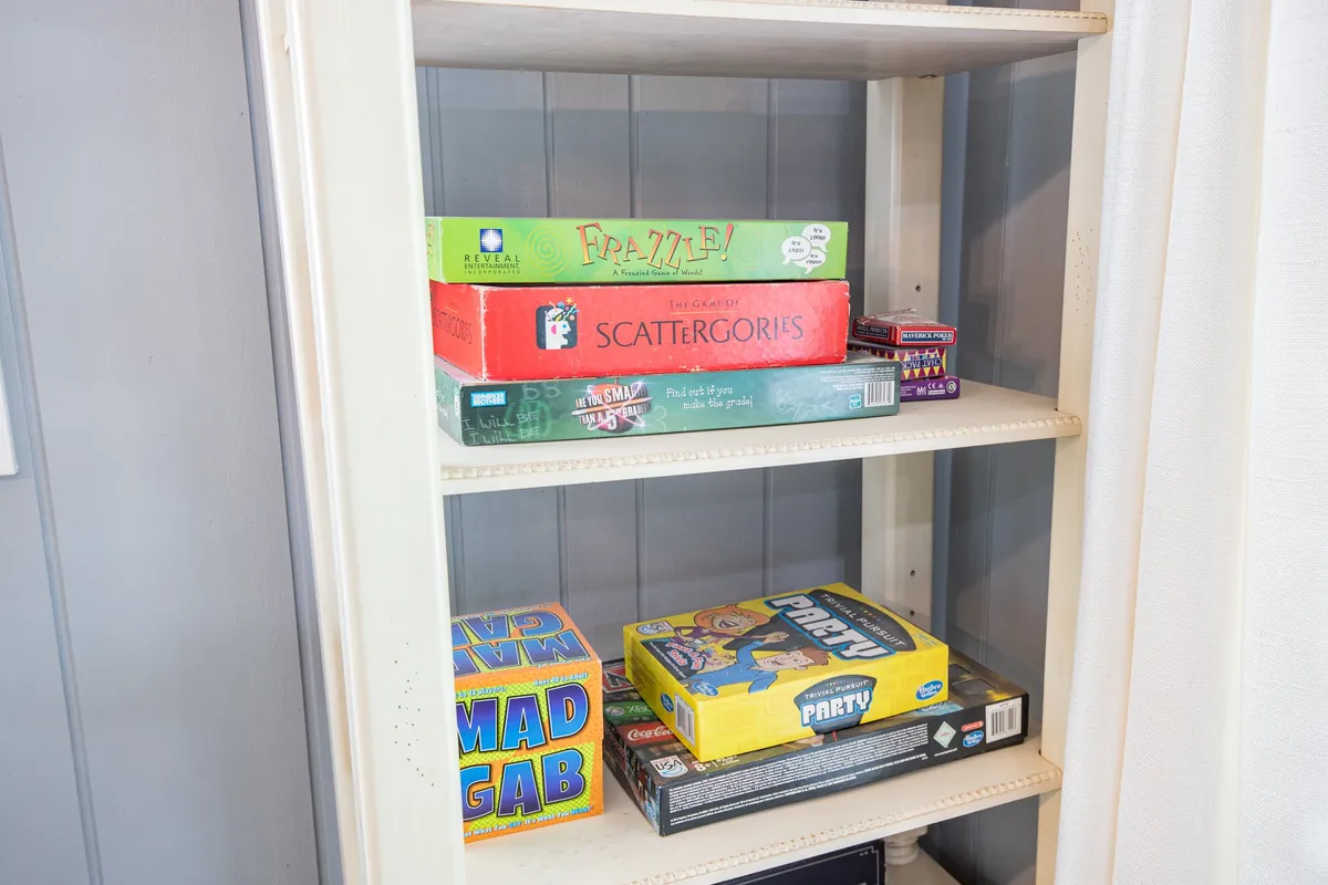 A lively scene with board games laid out on a table and shelving in the background, evoking the sense of family game nights and joyful social gatherings. The space feels cheerful and nostalgic, perfectly embodying the playful side of the social hub described.